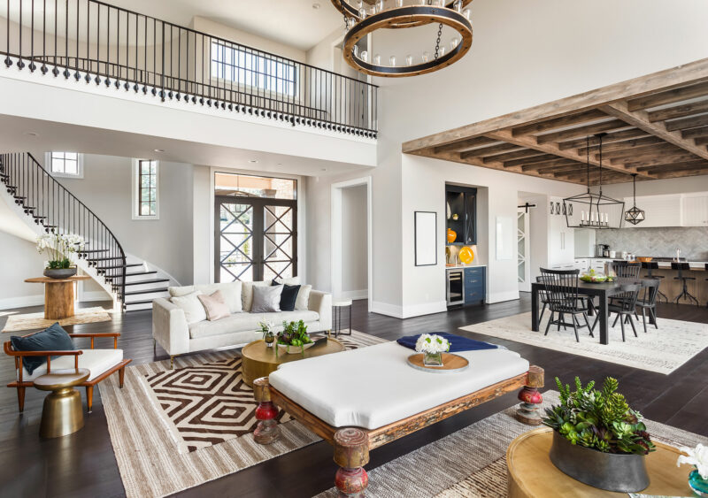 living room with kitchen in background and staircase leading upstairs